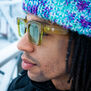A young man wearing a pair of green sunglasses with thick frame.