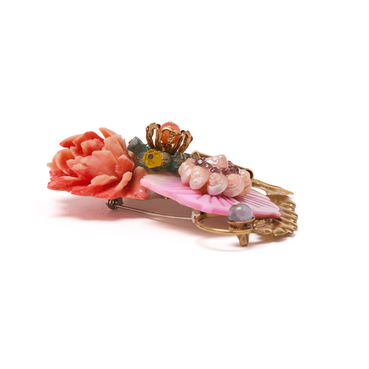 The back of a pink and gold brooch with flower shaped mother-of-pearl and vintage stones.