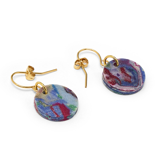 Two hook earrings featuring a round pendant in a marbled multicoloured pattern are laid out on a white background.