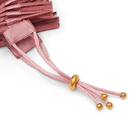 Close up of a pink fabric bracelet.