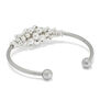 The back of a silver cuff bracelet with silver beads at its centre.