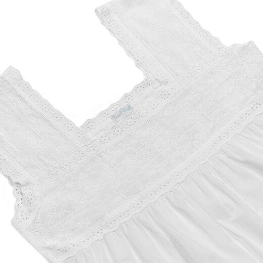 Close up of a white cotton nightdress featuring an embroidered square neckline.