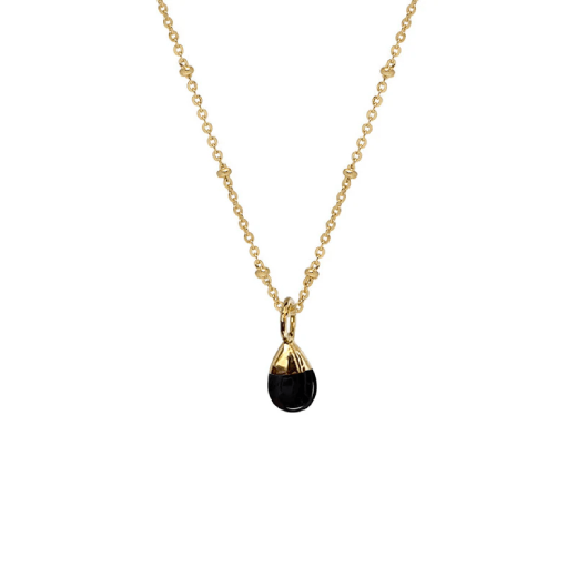 A gold chain necklace with a round black onyx pendant.