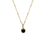 A gold chain necklace with a round black onyx pendant.