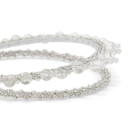 A detail of a metallic headband embellished with glass beads of various sizes.