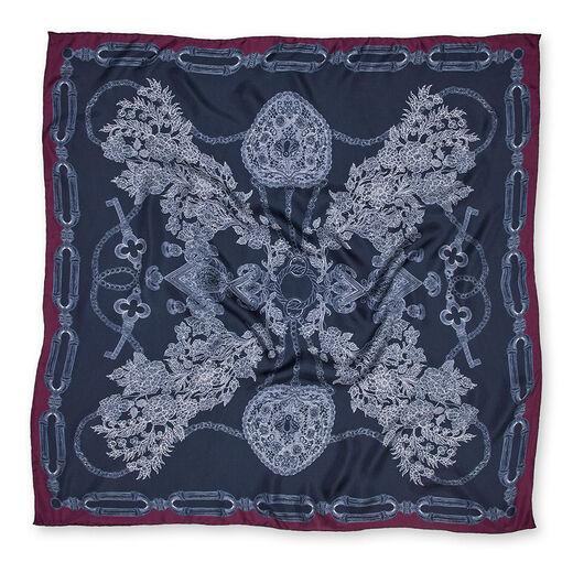 A square navy blue scarf with a purple border. It features a print of an intricate illustration of ornate jewellery items.