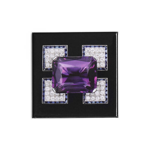 A square black magnet featuring a diamond brooch with a large rectangular purple amethyst at its centre