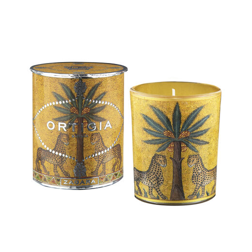 A scented candle in a decorative packaging featuring an illustration of a palm tree.