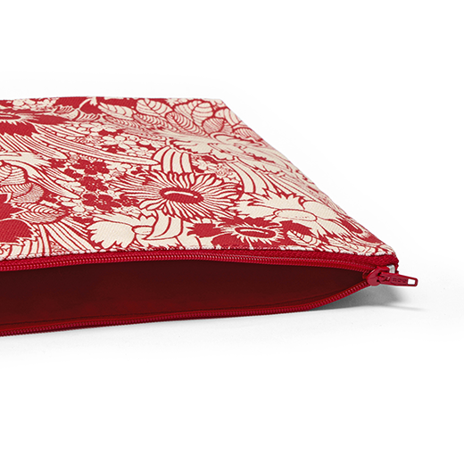 A close up of a zip travel pouch featuring a red and white floral pattern.