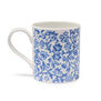 A white china mug with a pattern featuring a blue floral pattern.