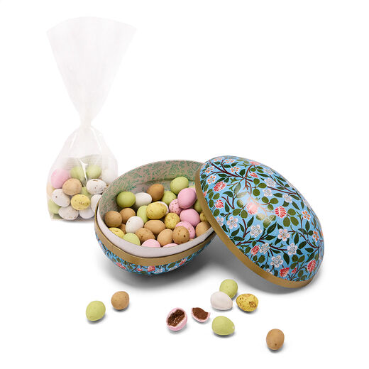 An egg shaped paper mache box filled with pastel coloured mini chocolate eggs.