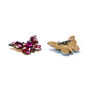 Two butterfly-shaped brooches. One is made of red gleaming stones and glass beads while the other is turned to show the clasp at its back.