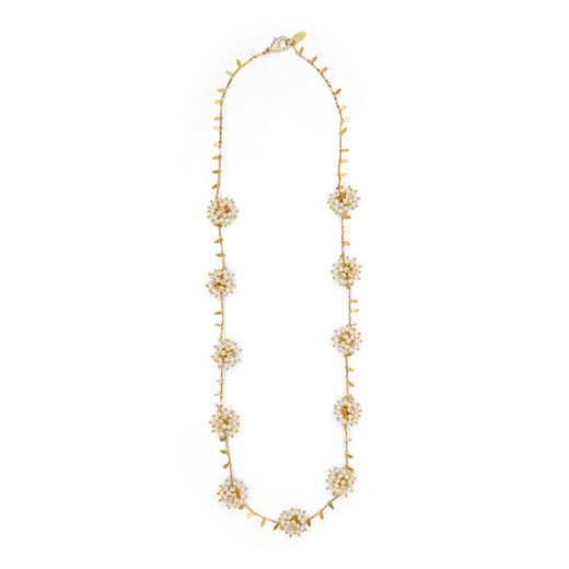 A long gold necklace with clusters of white faux pearls imitating flowers.