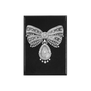 A rectangular magnet with a black background and a photograph of diamond and rock crystal jewellery in the shape of a tied ribbon