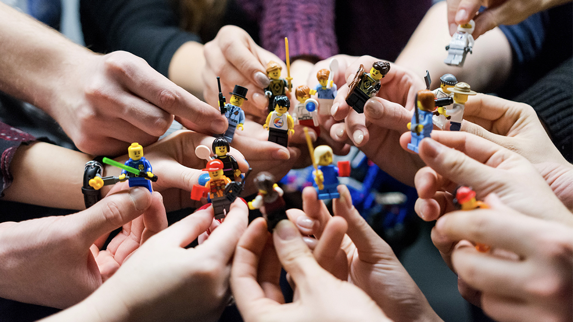 People holding miniature Lego figures