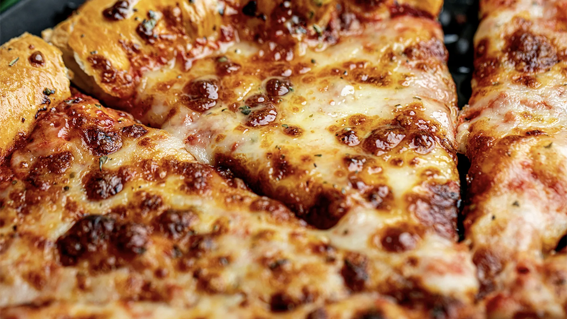 A close up of a cheesy pizza