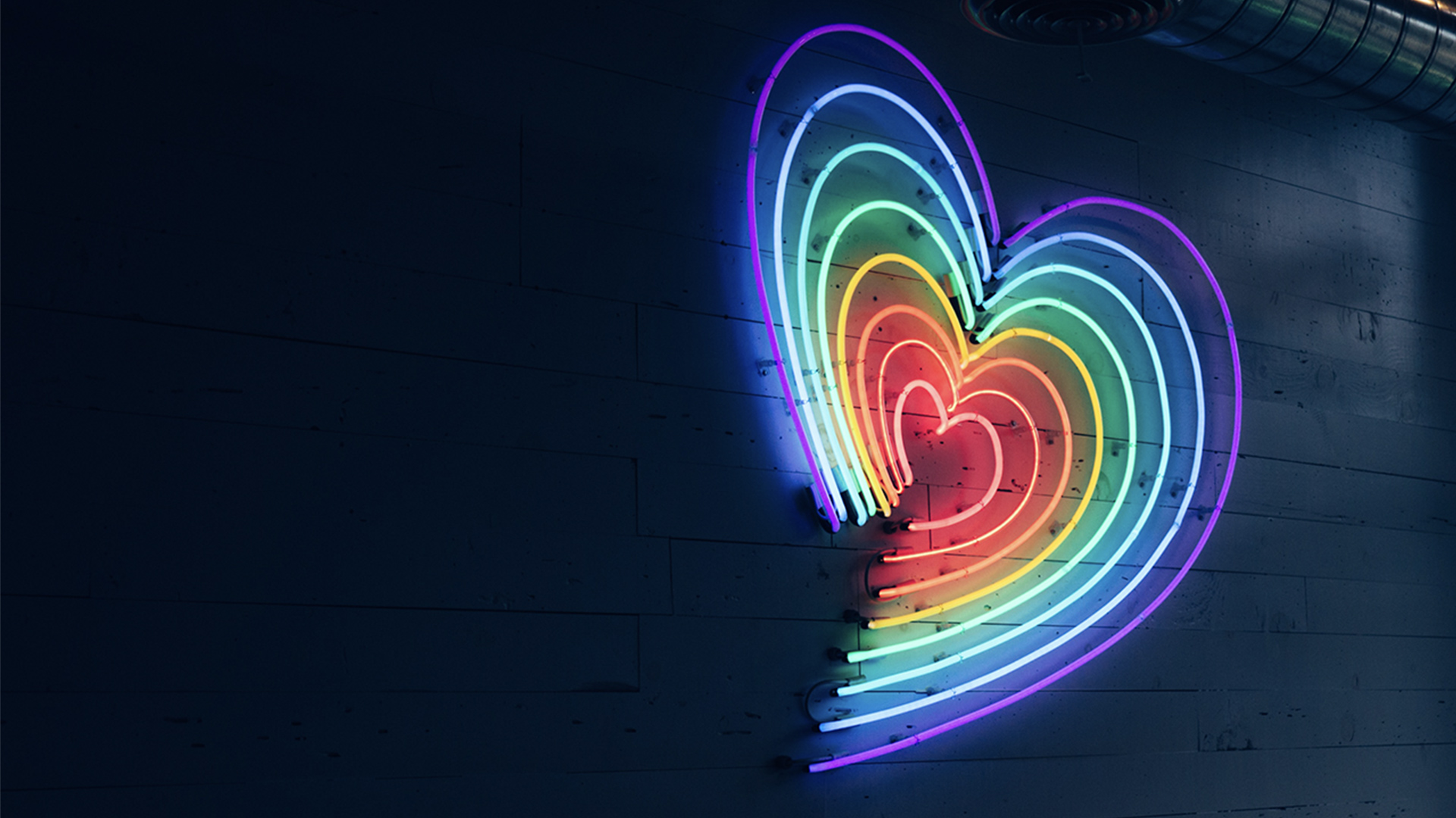 Multicoloured heart LED light on a wall