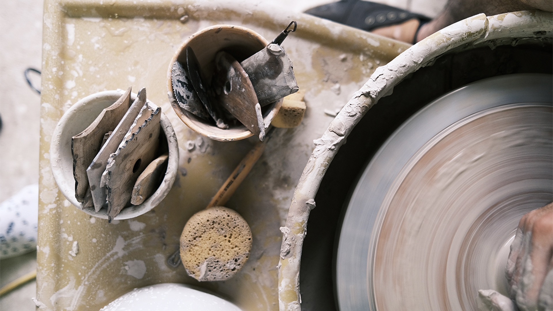 Close up of potters tools whilst they work clay on a wheel
