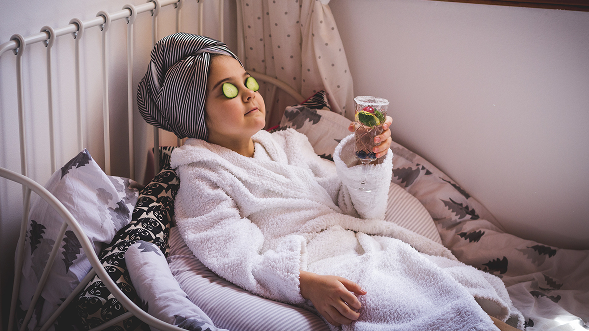 Girl relaxing in a bathrobe and drinking fruit water