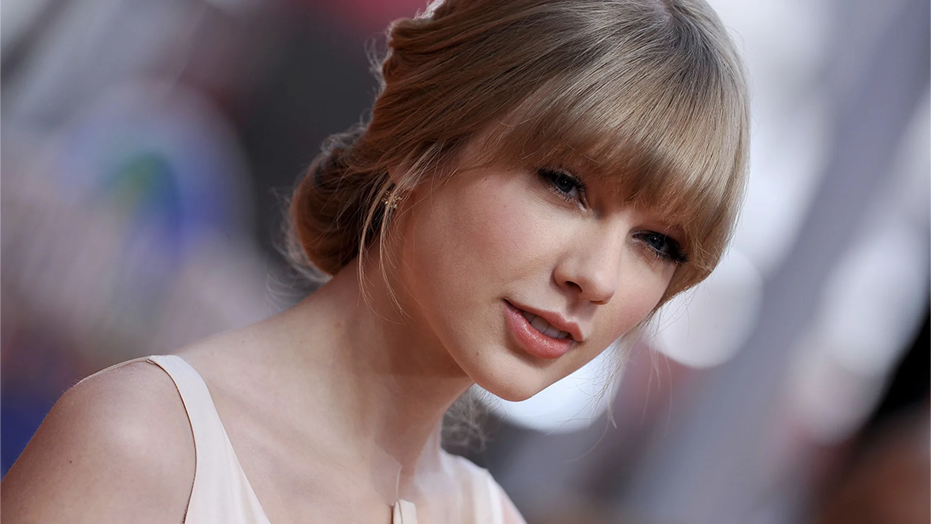 Close-up of Taylor Swift at premiere against blurred background.