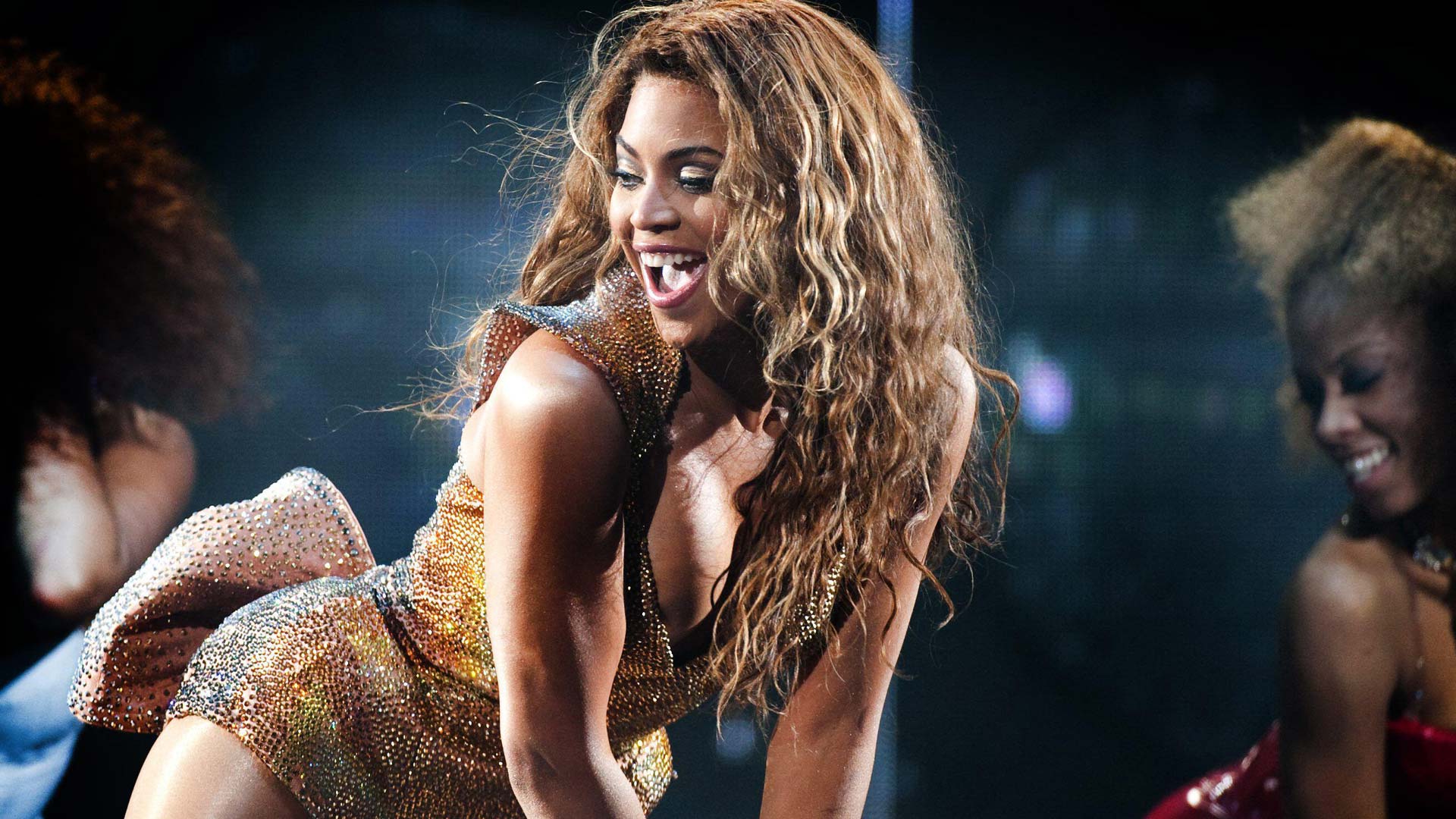 Beyonce dancing in a golden outfit at her concert