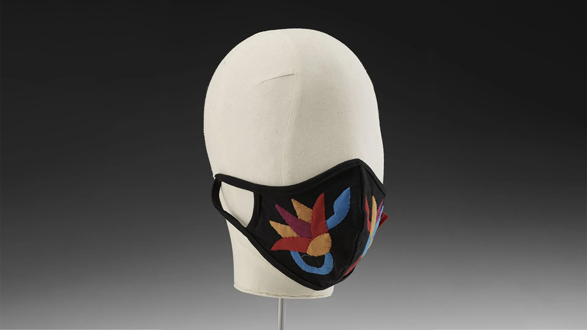 Mask in black fabric decorated with floral pattern