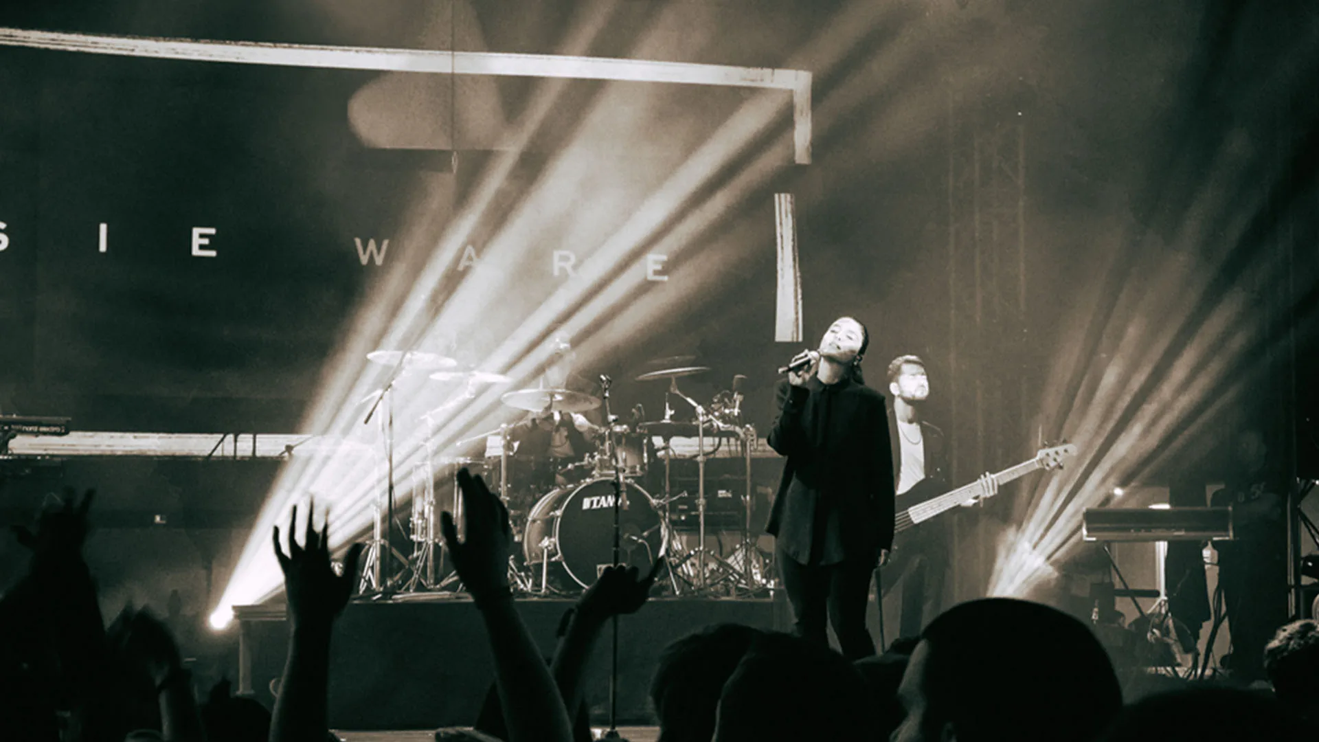 Black and white shot of Jessie Ware performing on stage.