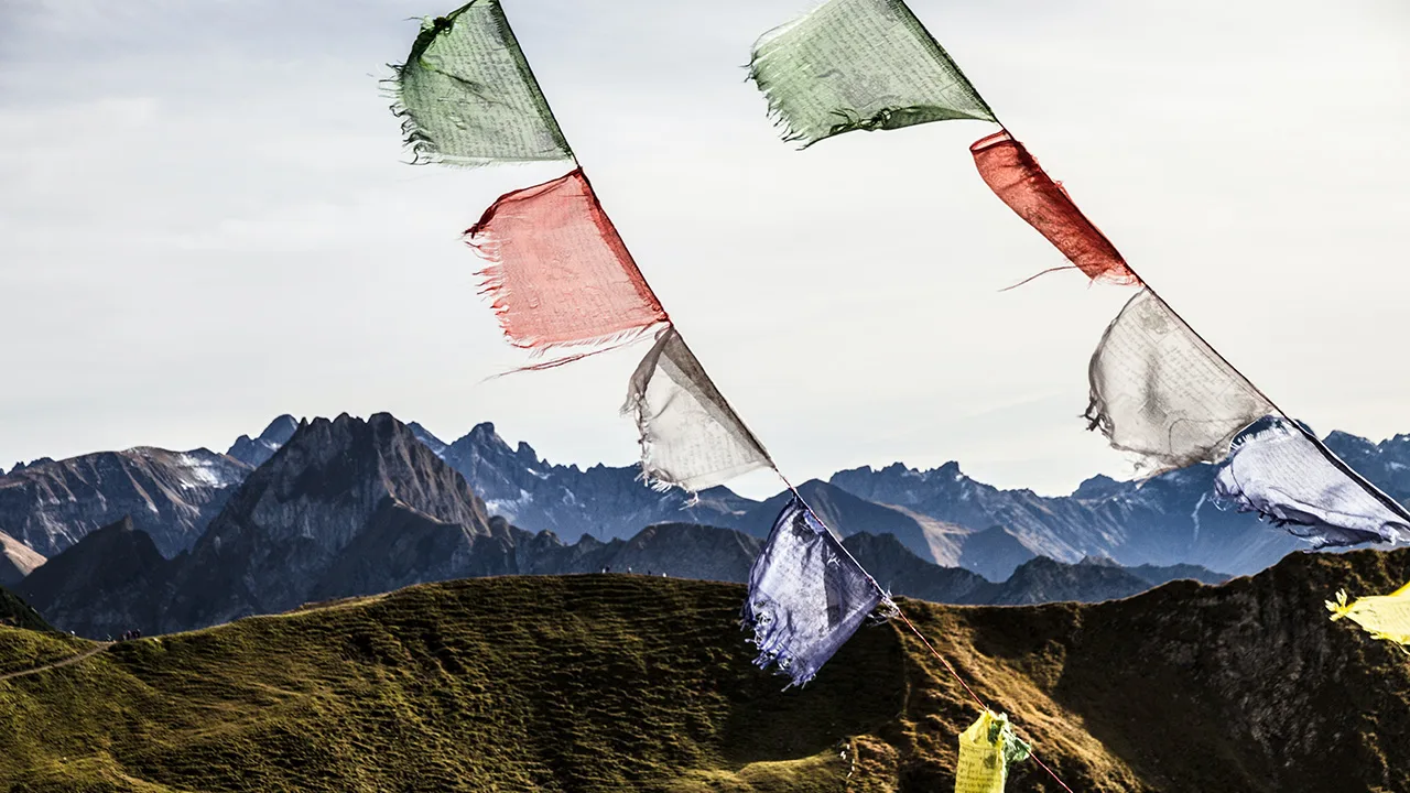 Flags hang up with a mountain background