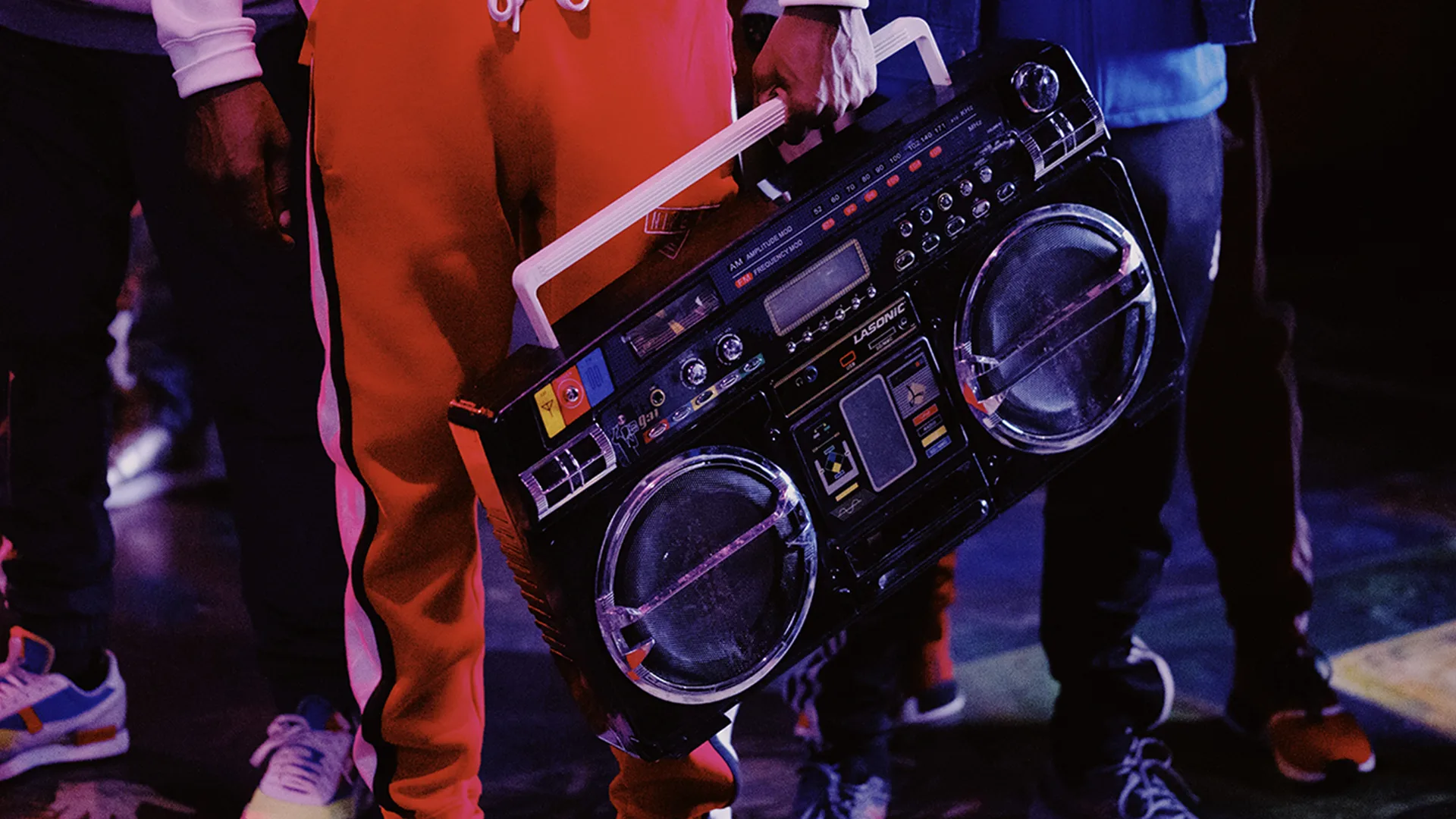 man in red tracksuit holding a boombox