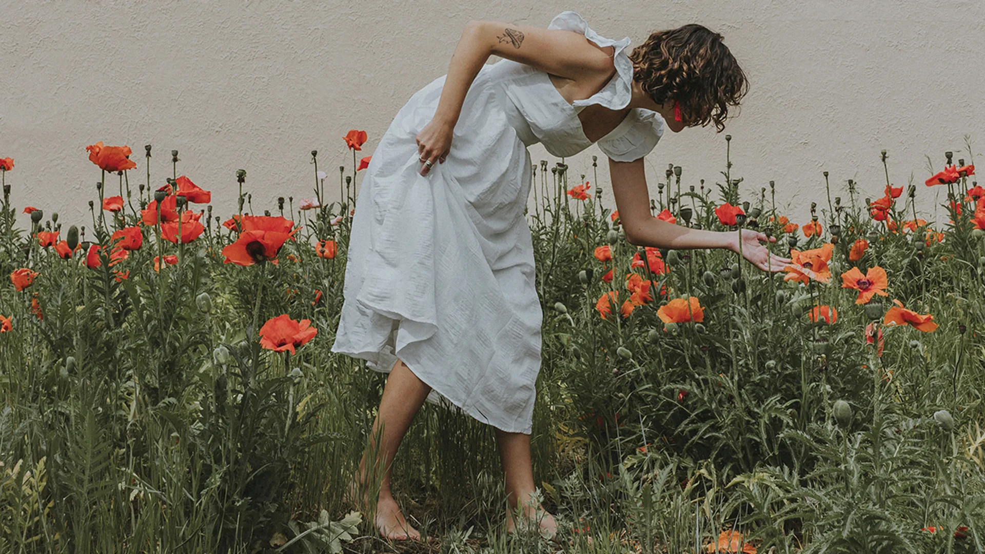 A woman looking at red flowers