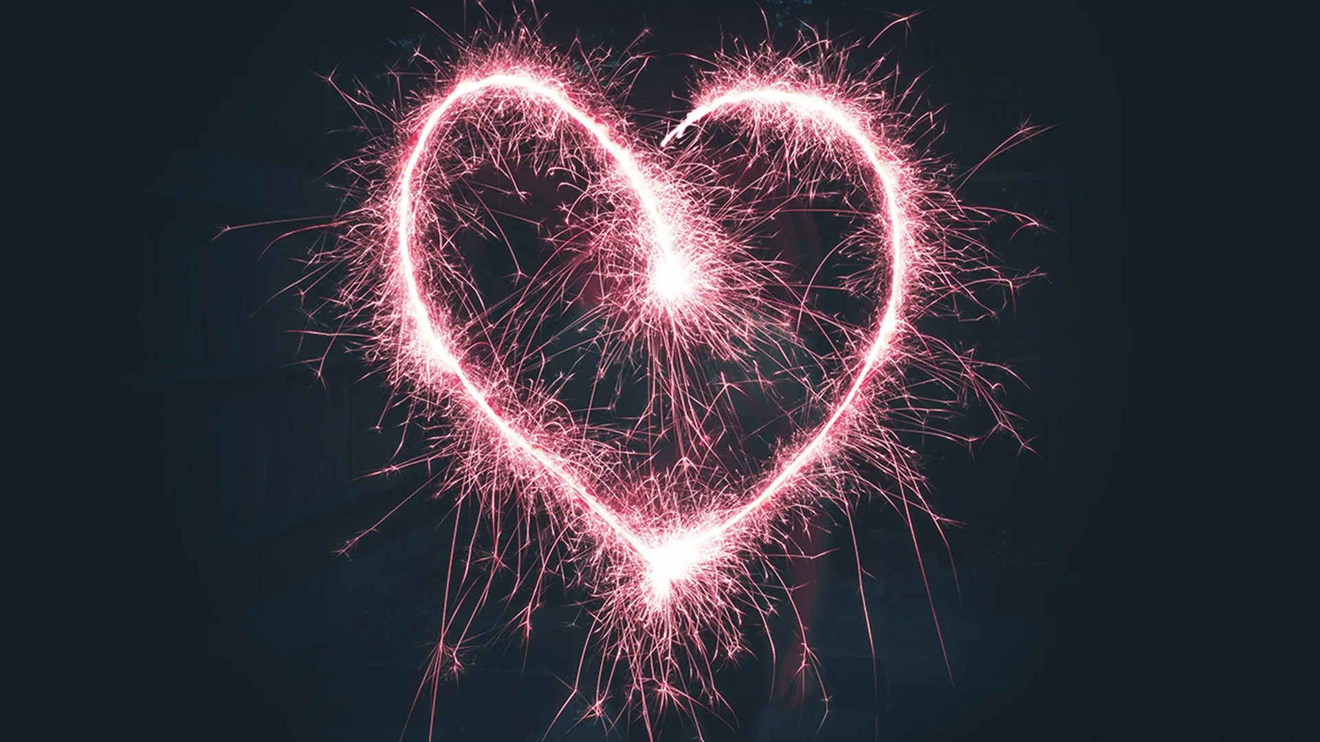 Love heart shape drawn by pink sparkler