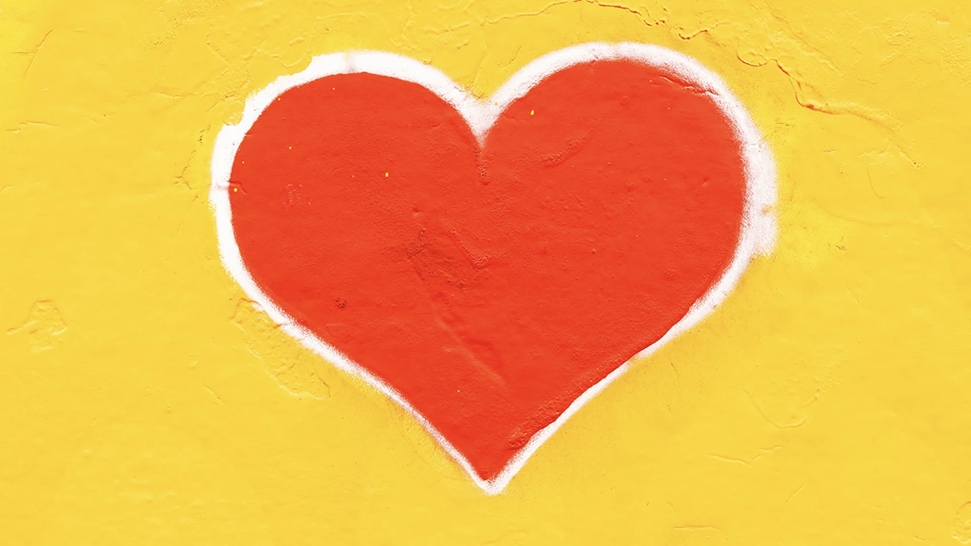 A red heart on a yellow wall