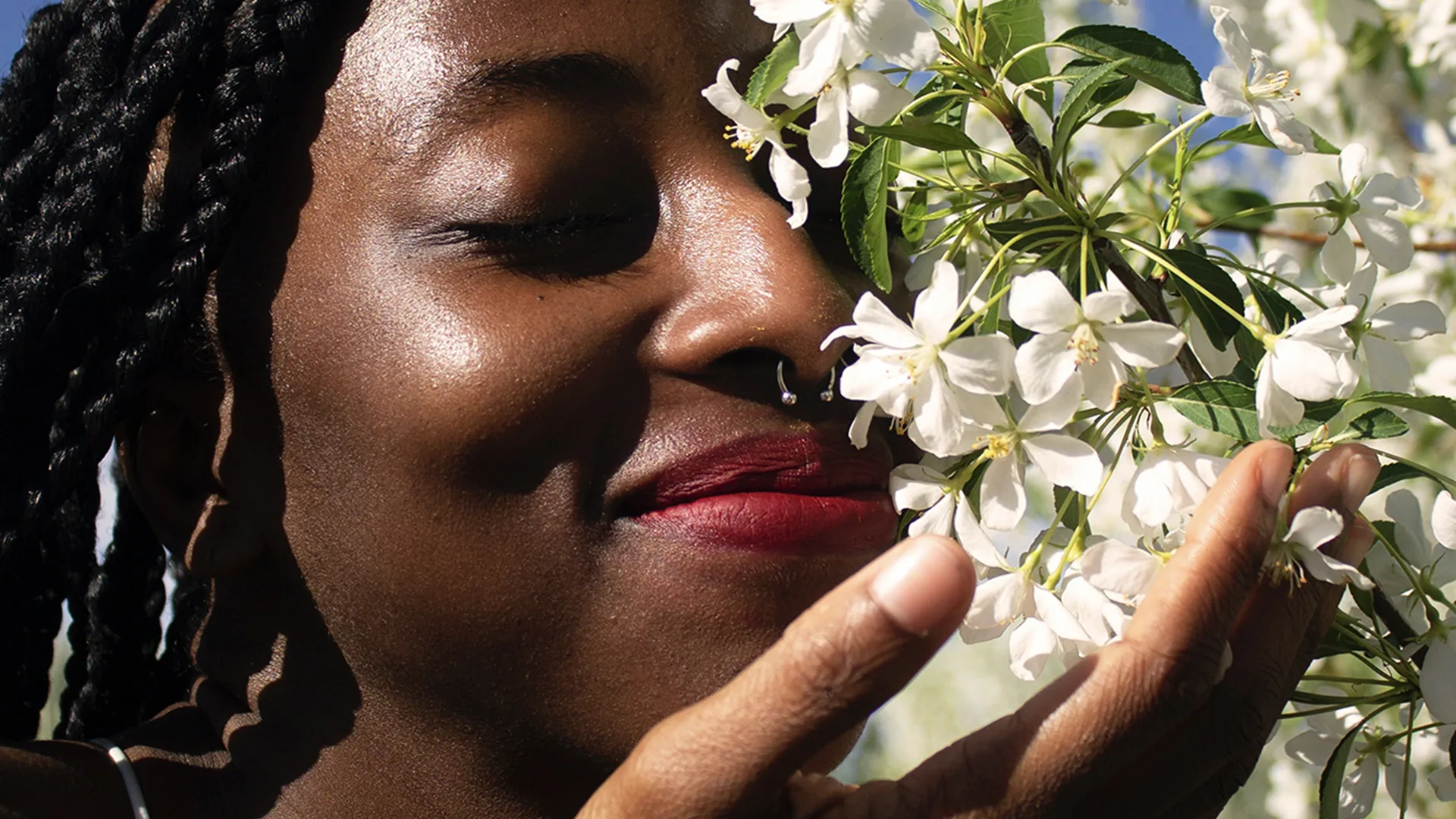 Woman sniffing some flowers and smiling