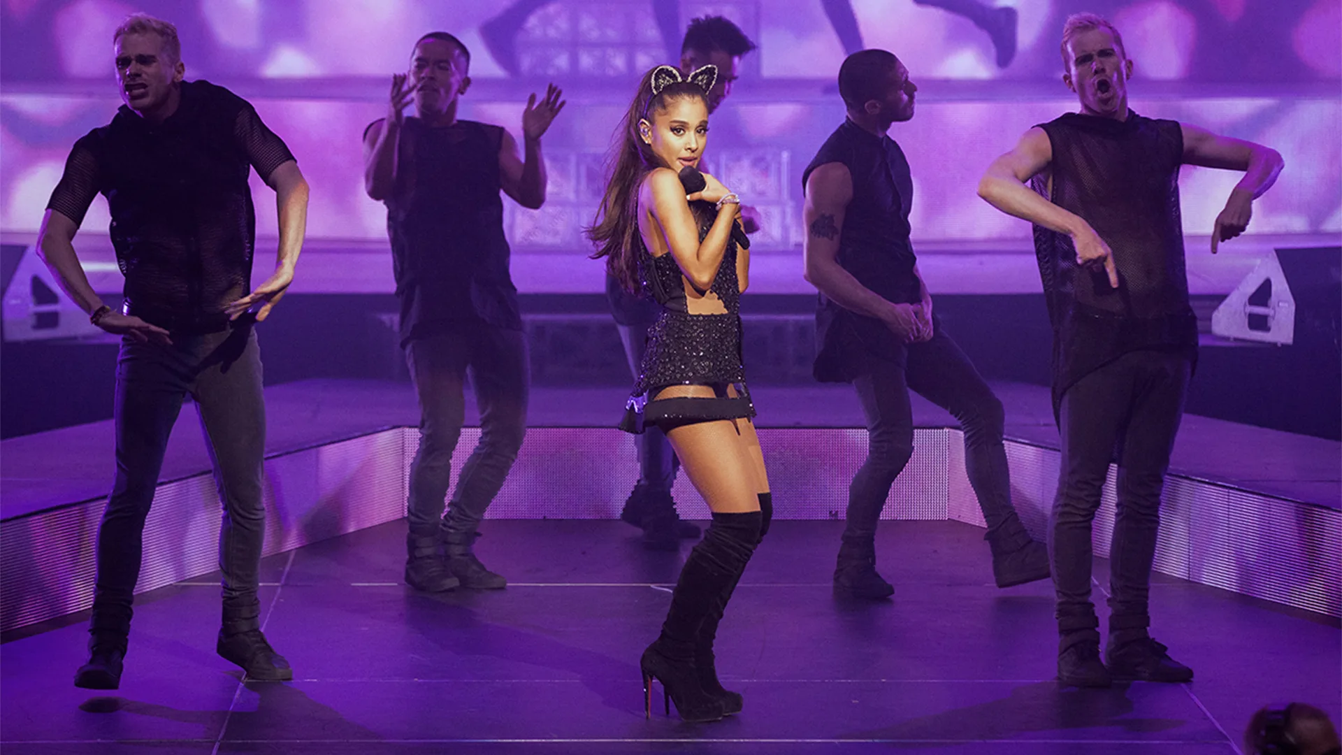 Ariana performing on stage with back up dancers
