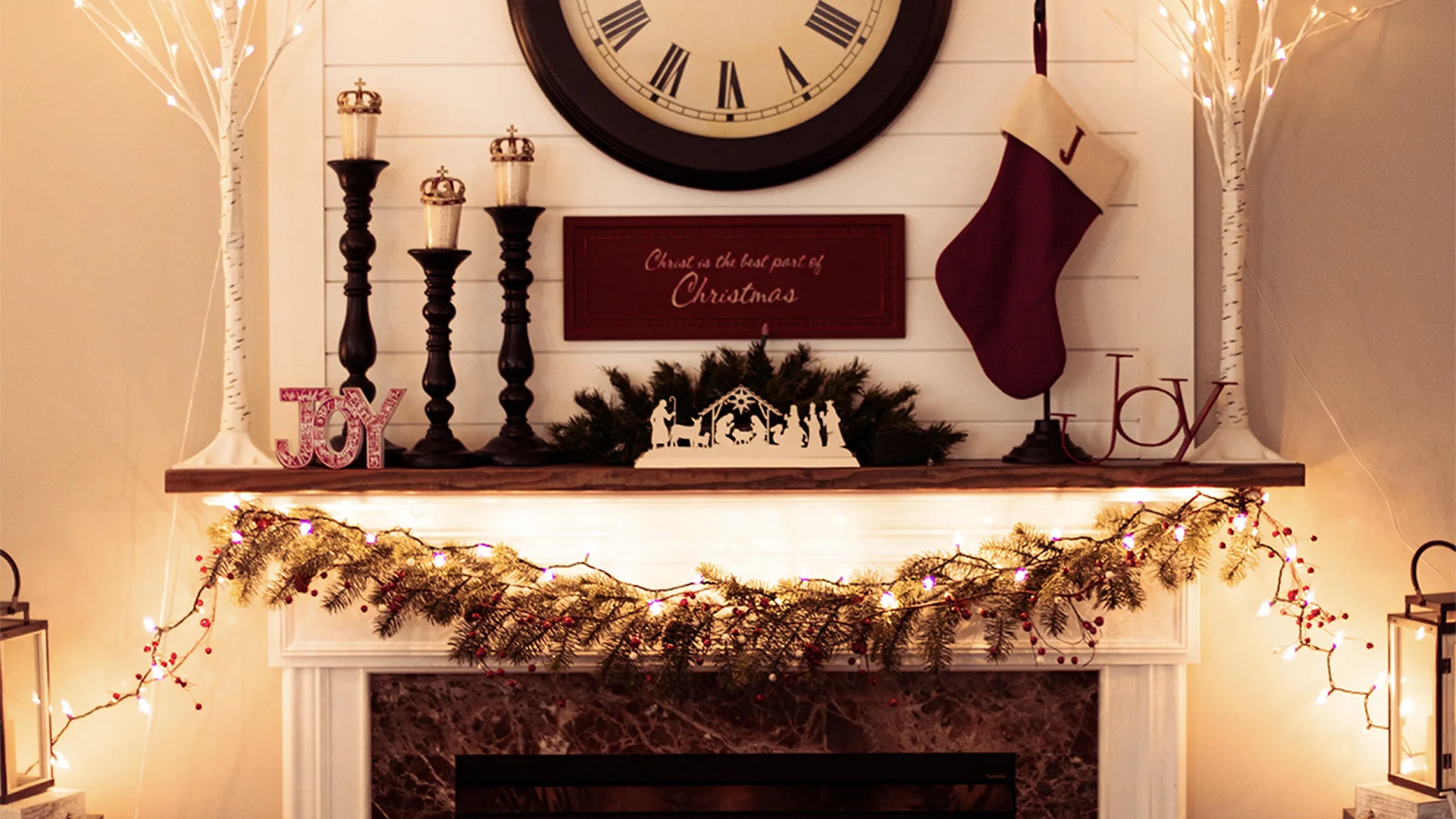 Christmas decorated fireplace with clock above