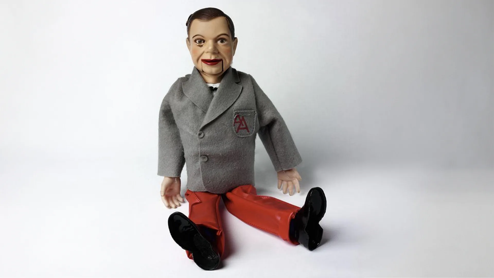 Archie Andrews, a doll wearing a grey and red suit