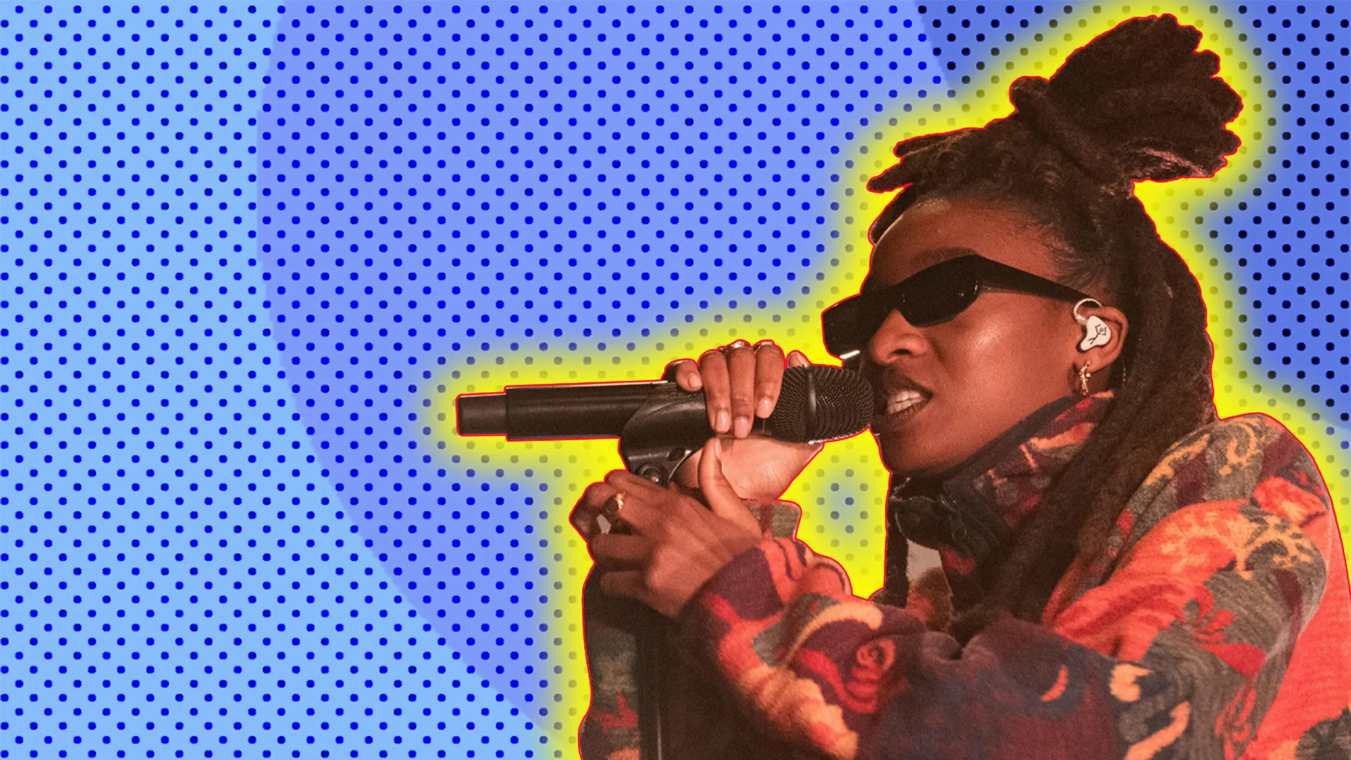 Little Simz performing with a yellow glow on a blue polka dot background