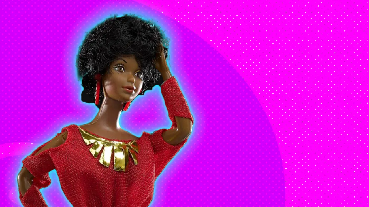 A photo of a barbie called Kitty Black Perkins, a dark skinned Barbie in a red dress with gold necklace stood against a pink background with blue halo.