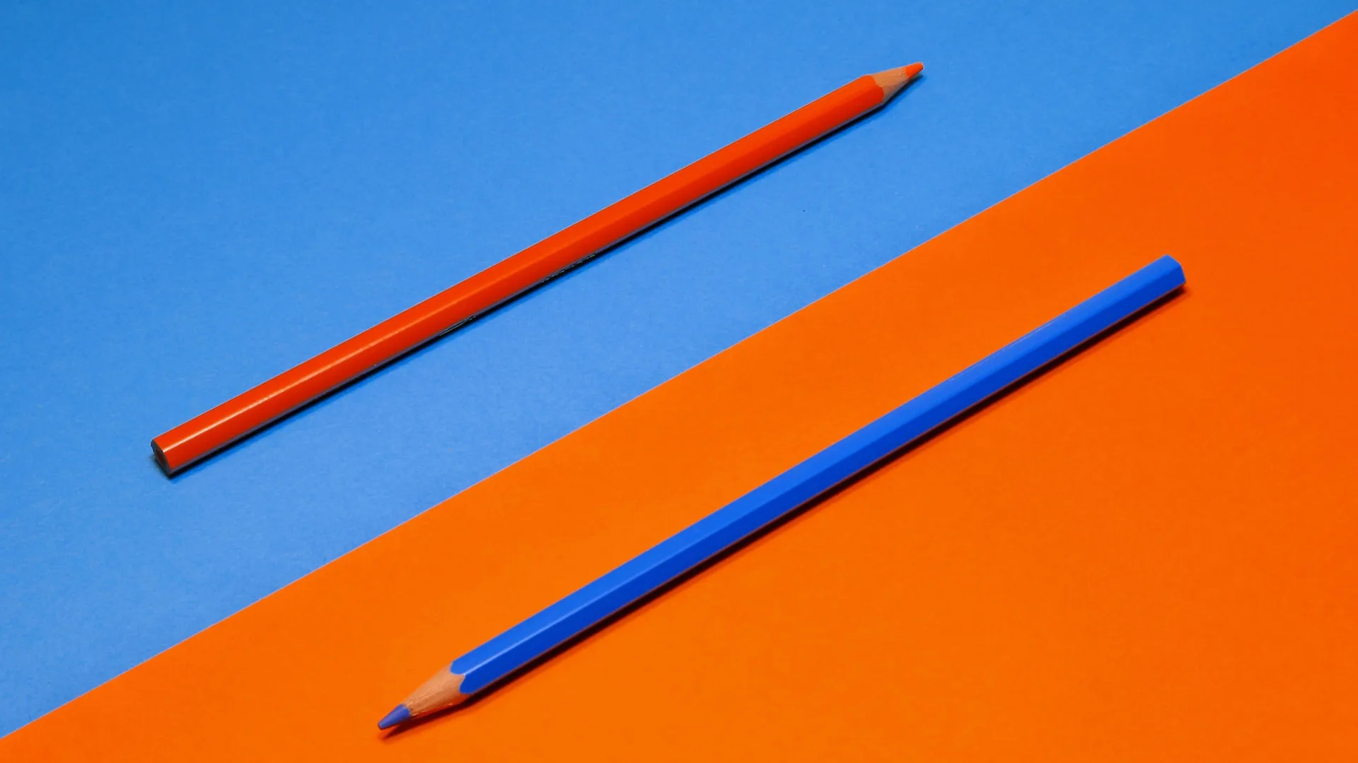 Orange and blue pencils on orange and blue paper