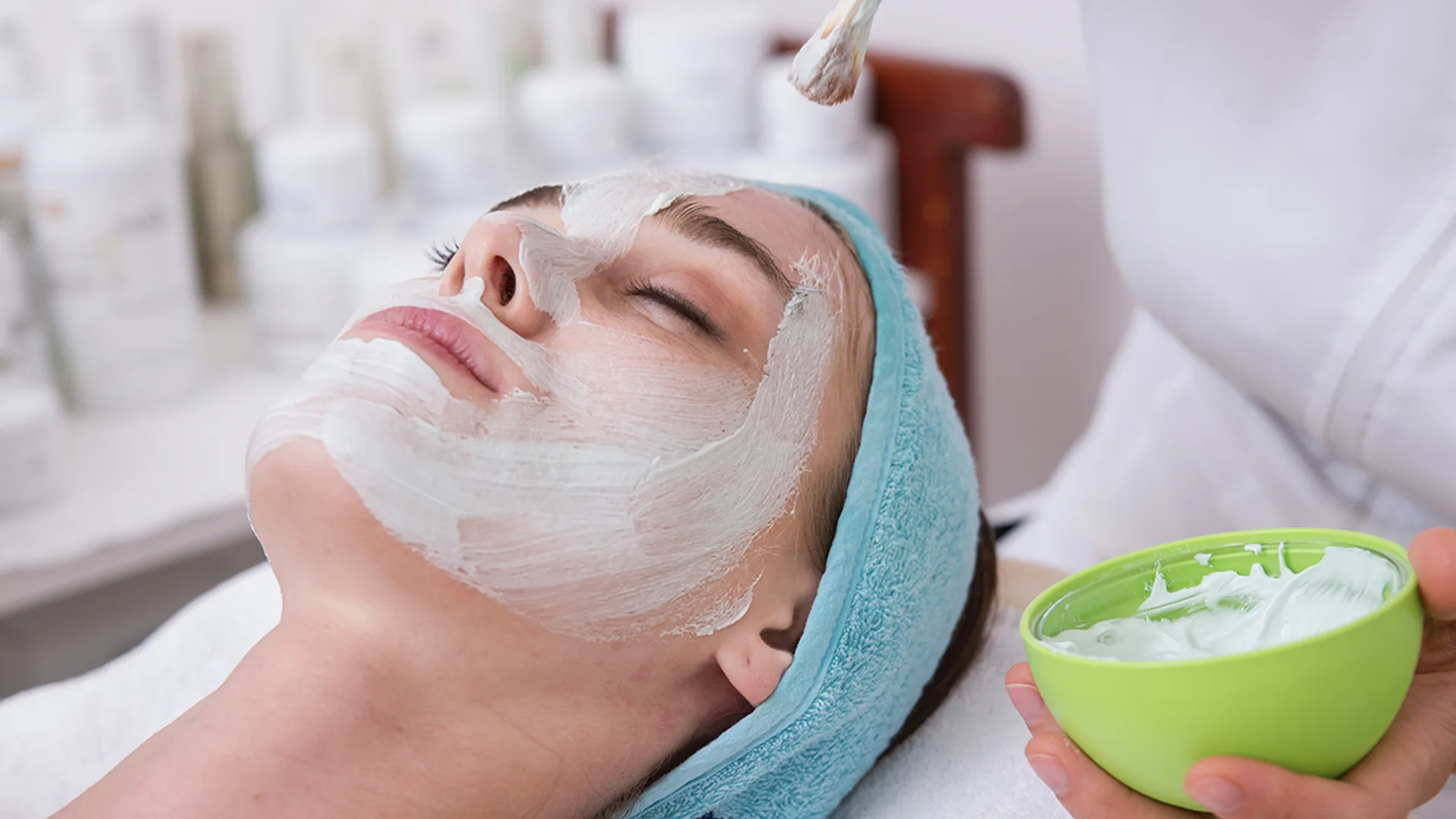 Women with face mask applied while laying down in spa