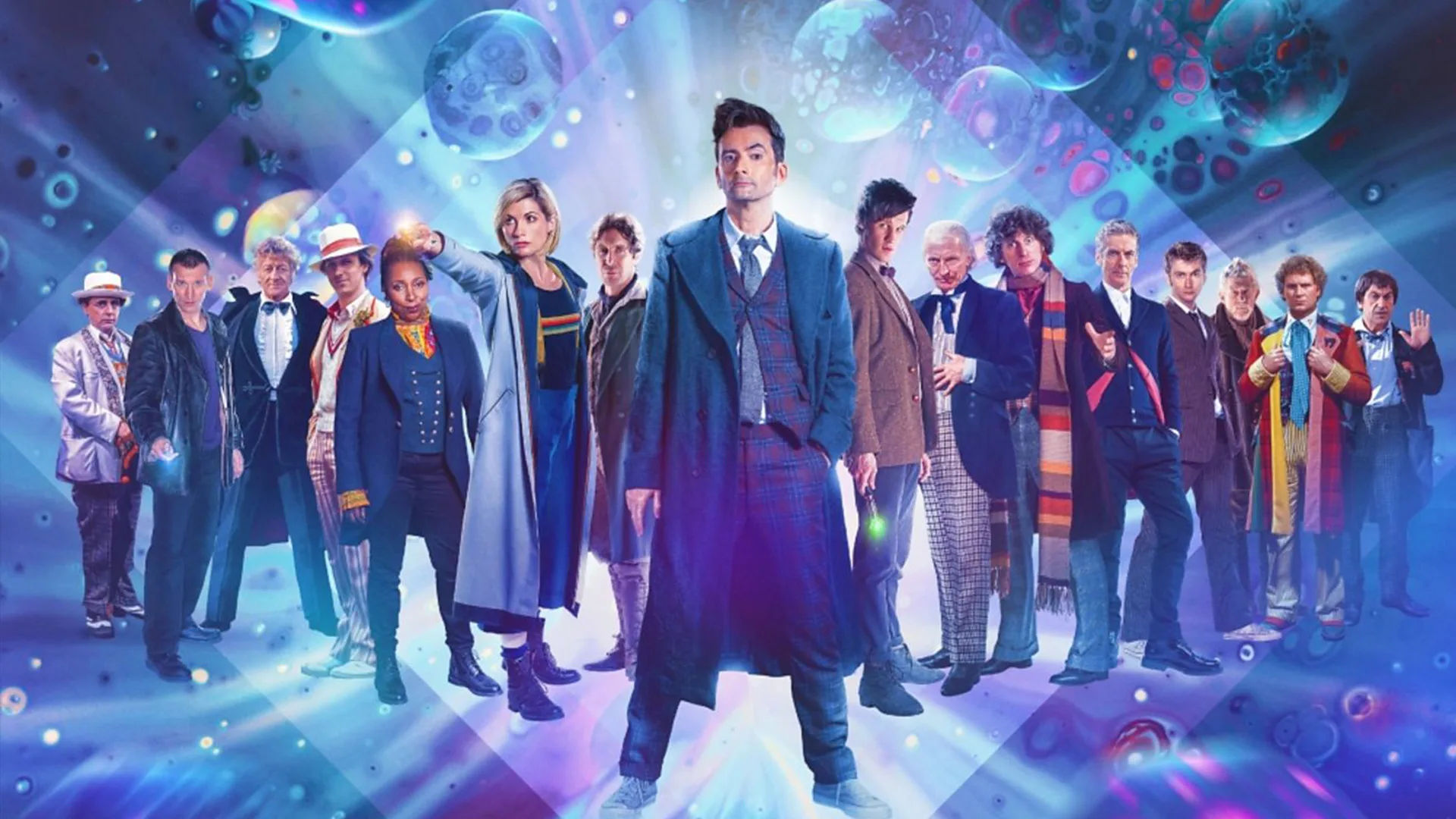 Cast of Doctor Who stood in a line against blue background