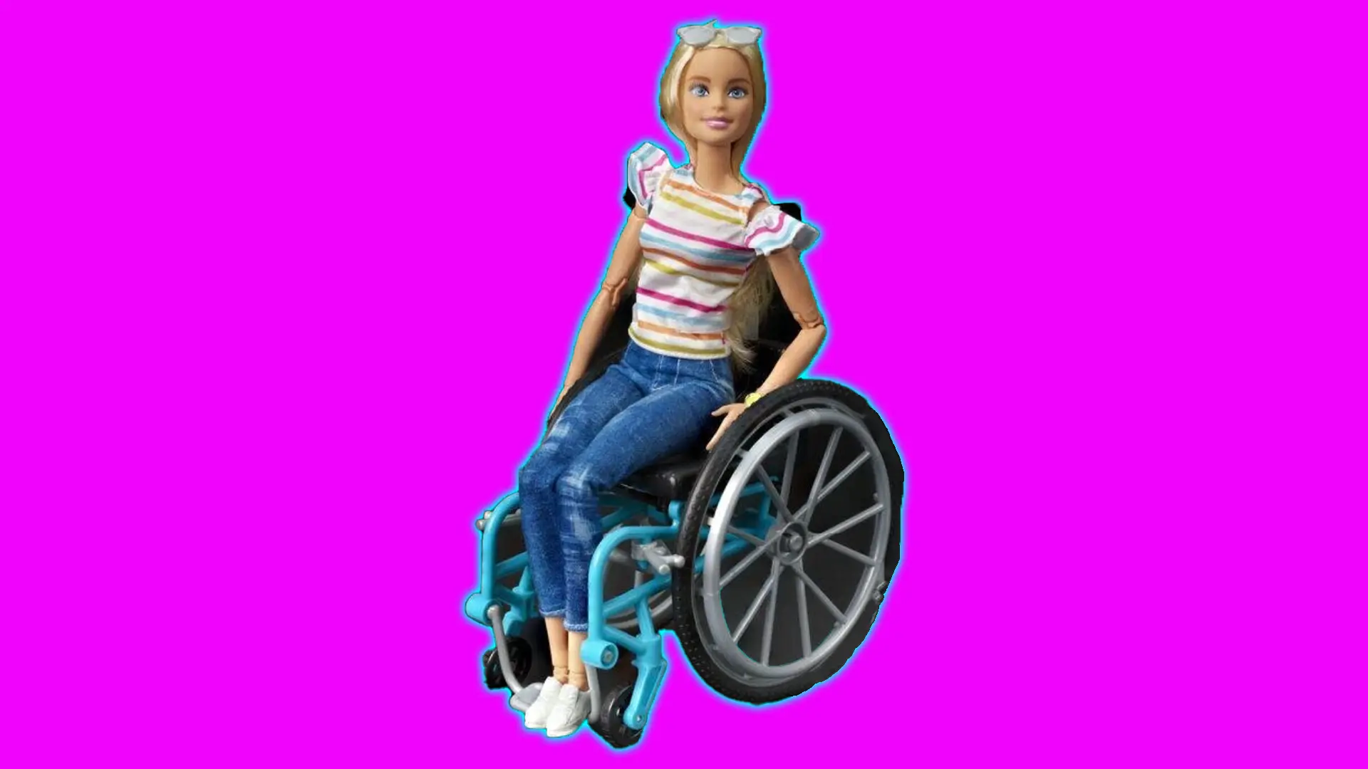 A photo of Barbie in a wheelchair wearing jeans and a striped top set against a pink background with blue halo.