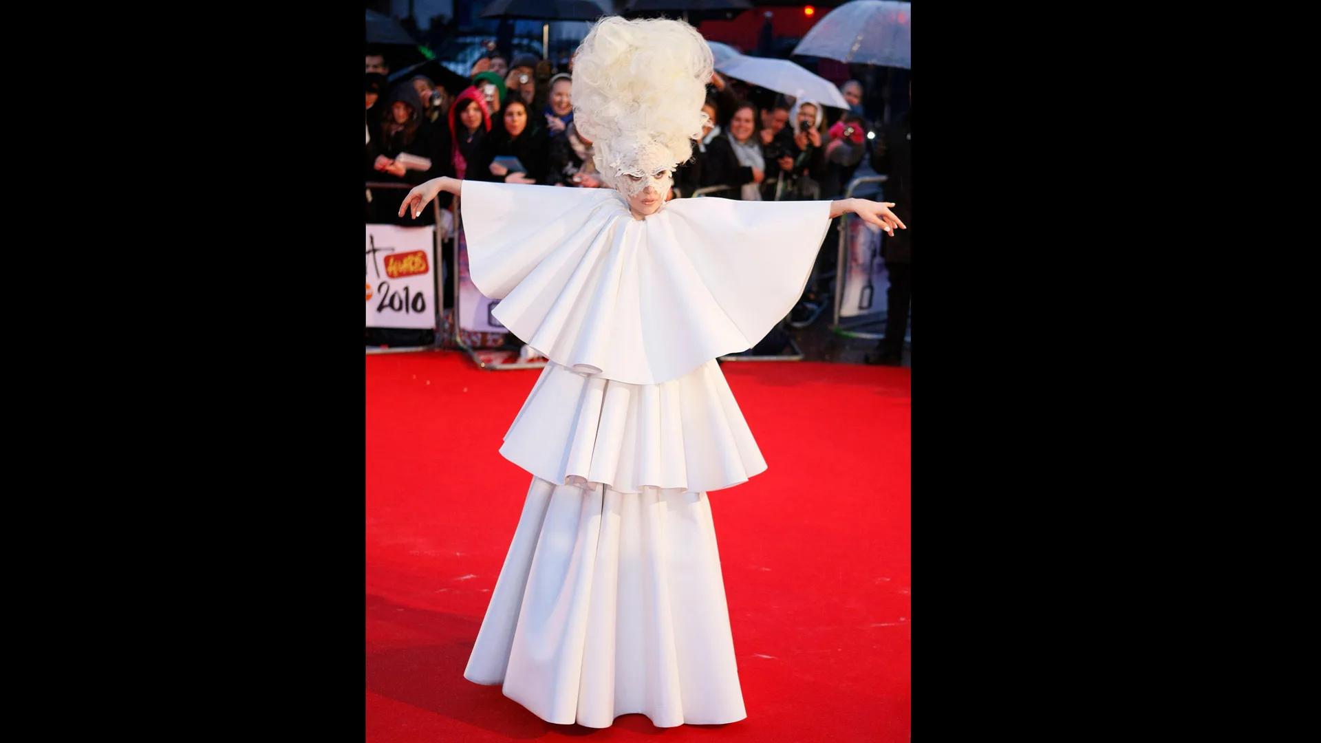 Photograph of Lady Gaga in a white outfit on the red carpet at the Brit Awards