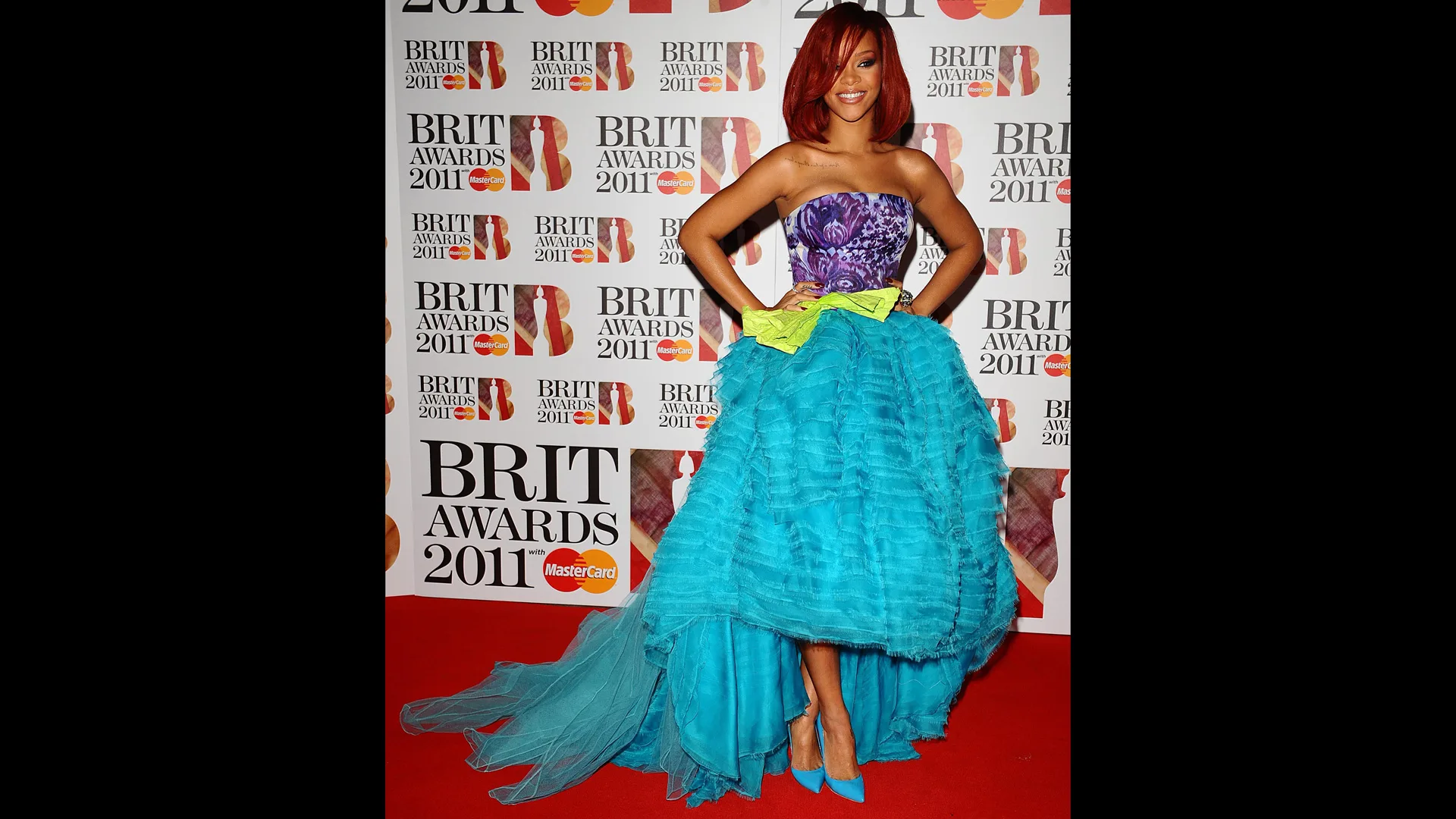 Photograph of Rihanna wearing a turquoise ballgown on the red carpt at the BRIT awards