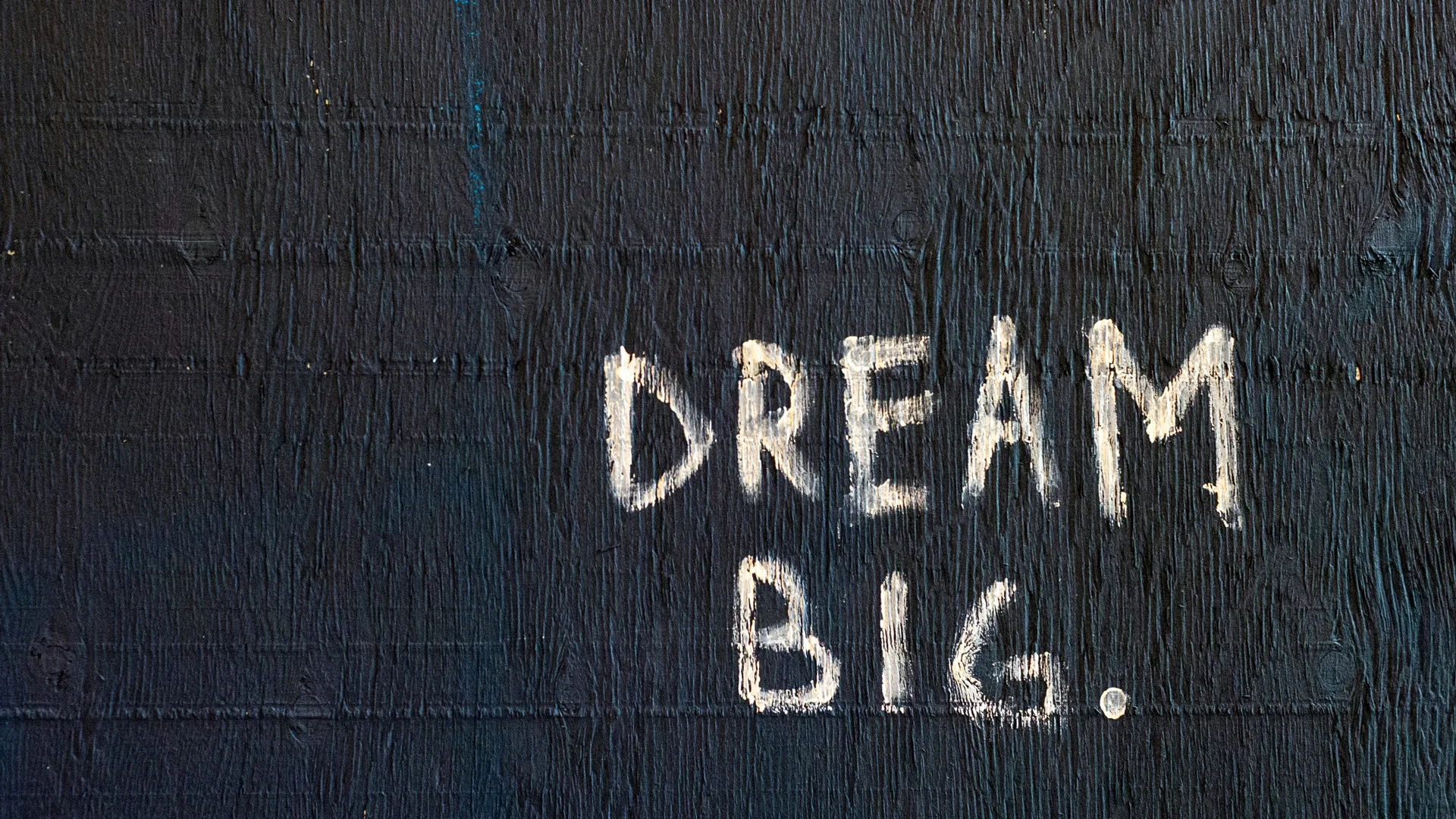 A brick wall with DREAM BIG written on it