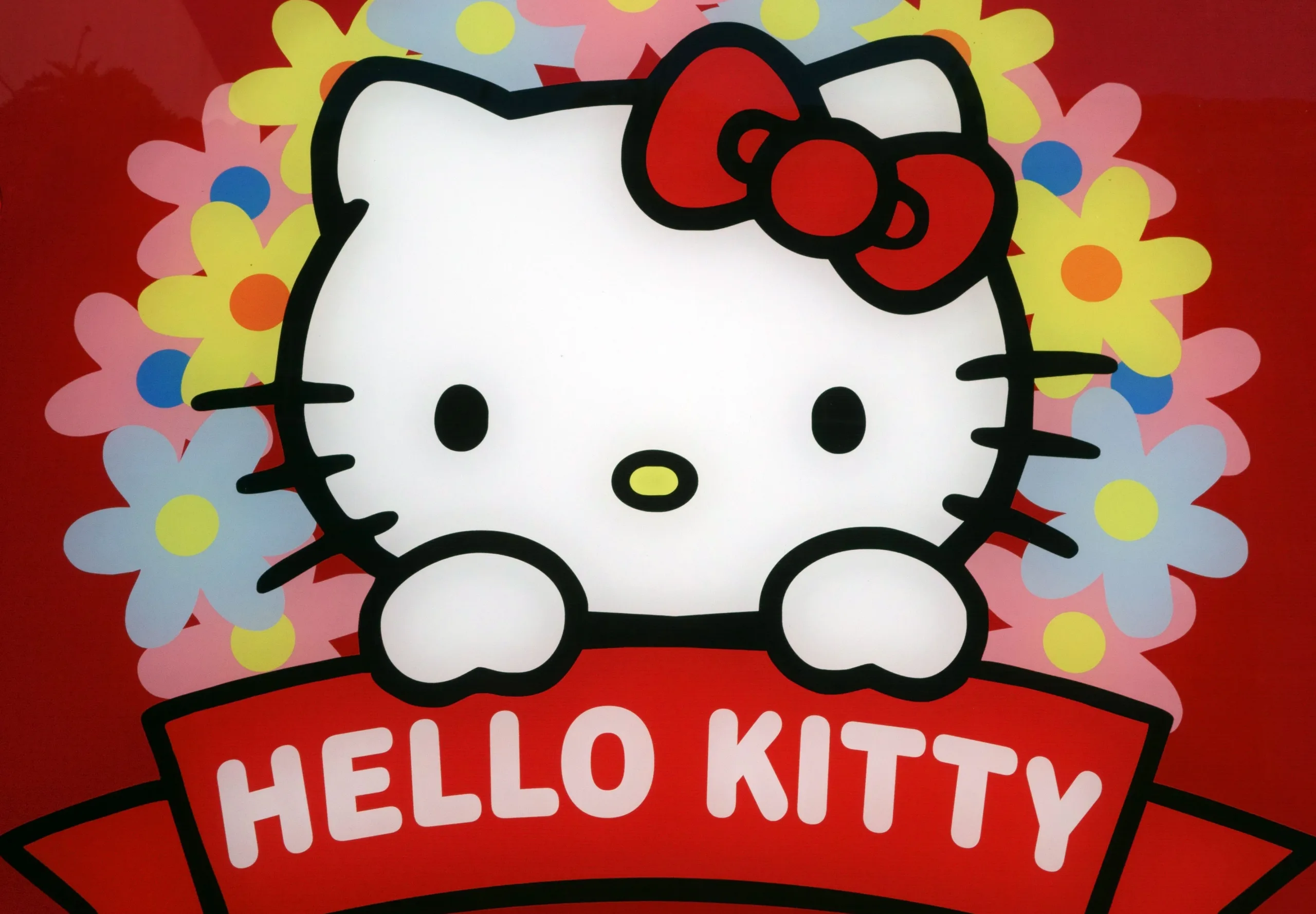 Hello Kitty peeking out over a sign that says Hello Kitty