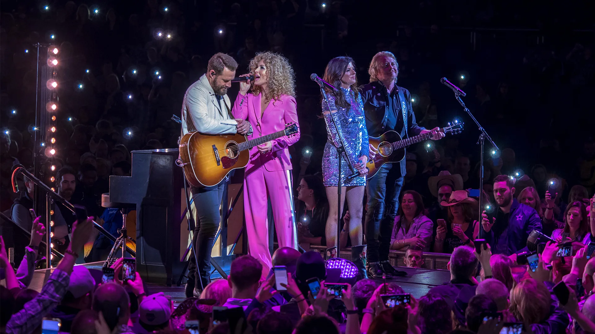The band Little Big Town perform on a stage to a crowd