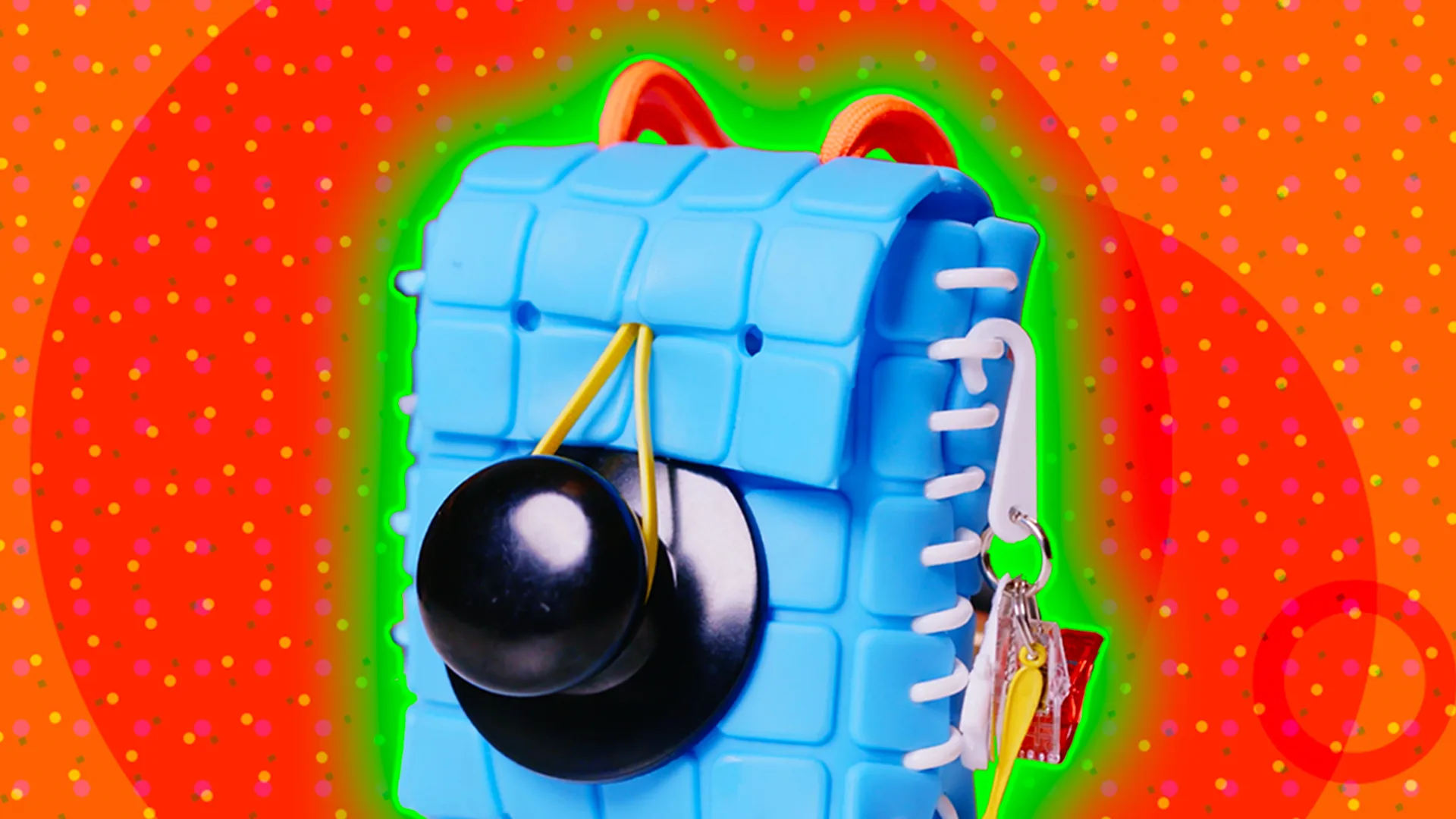A blue handbag with a black doorknob on the front against an orange background