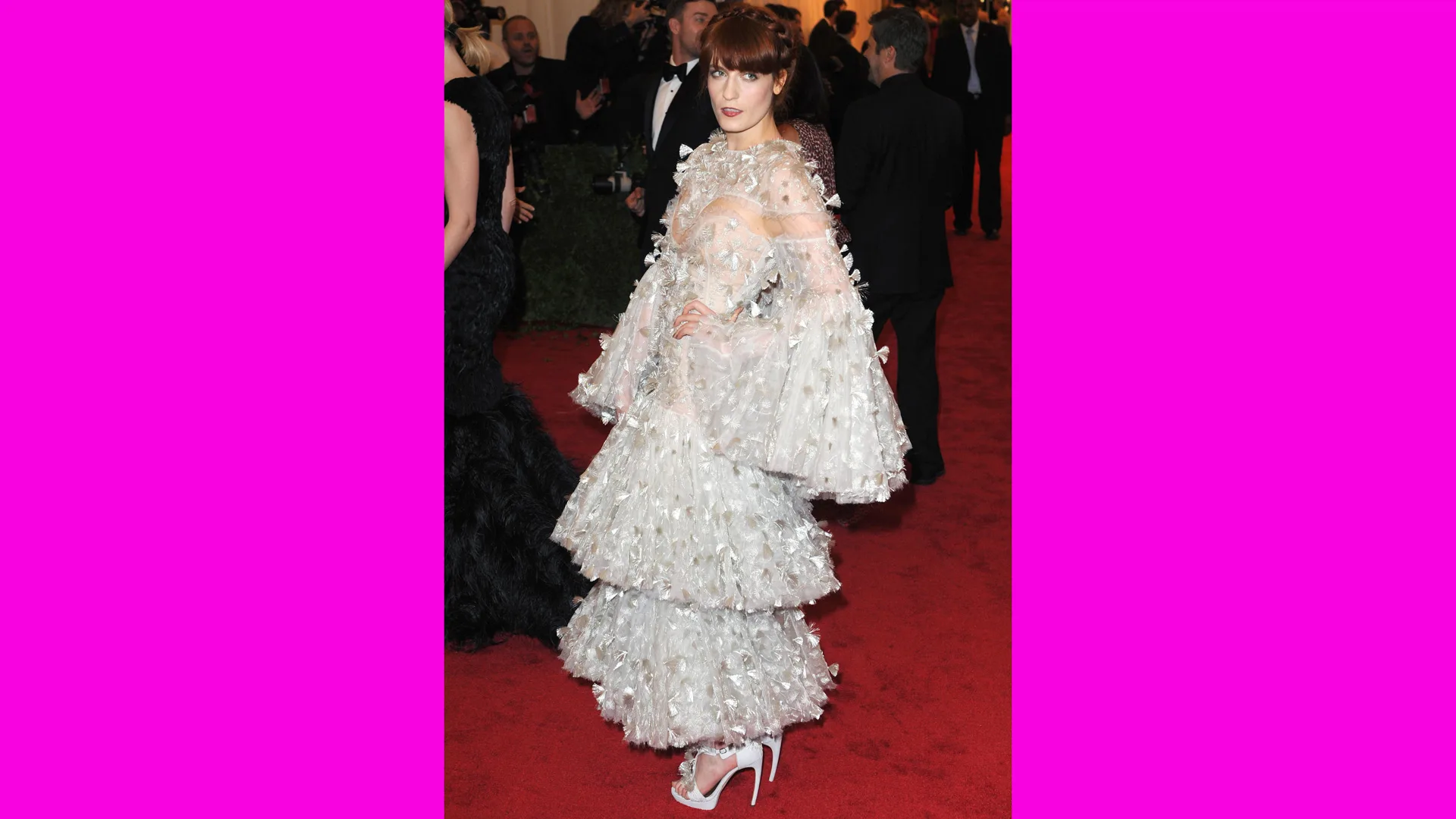 A photo of Florence Welch at the Met Gala wearing a white silver tiered ruffle dress