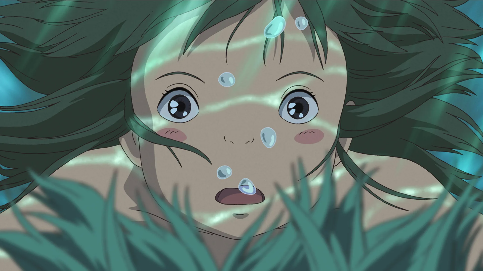 A still from the animated film Spirited Away showing a closeup of Chihiro's face underwater looking surprised